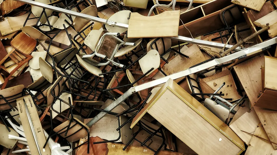 A pile of old wooden chairs